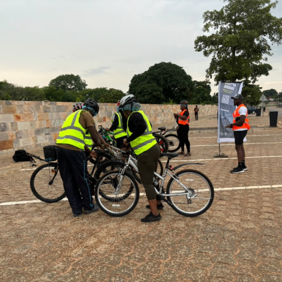 Semaine 4 · Rideurs After6 ajustant leurs vélos près de la banderole du point de rendez-vous