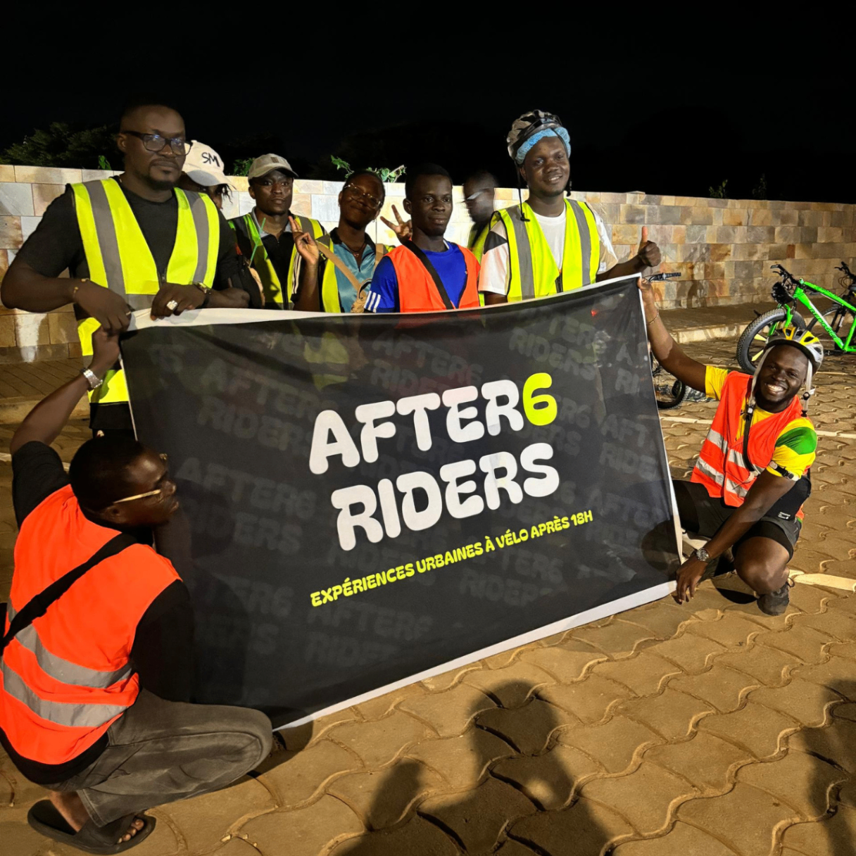 Semaine 4 · Photo de groupe nocturne du crew After6 avec la banderole officielle