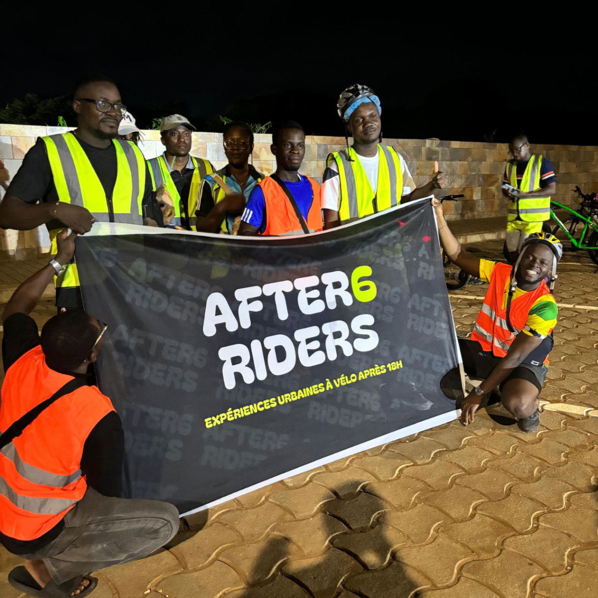 Semaine 4 · Riders After6 posant fièrement avec la banderole After6 Riders la nuit